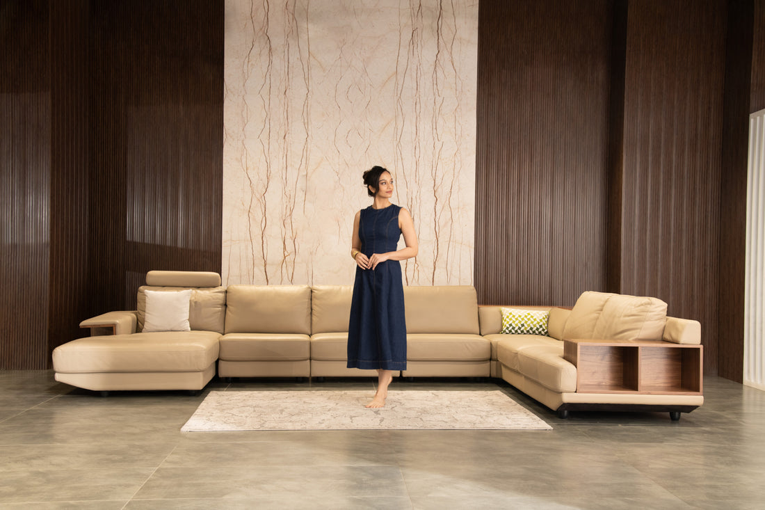 Woman standing in a modern living room with a beige sectional sofa.slider_item_GjB3Hq